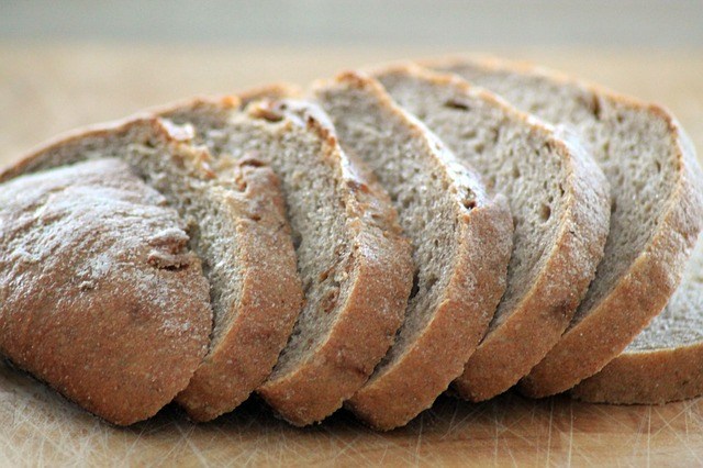 slice of fresh baked bread placed on wooden table close up